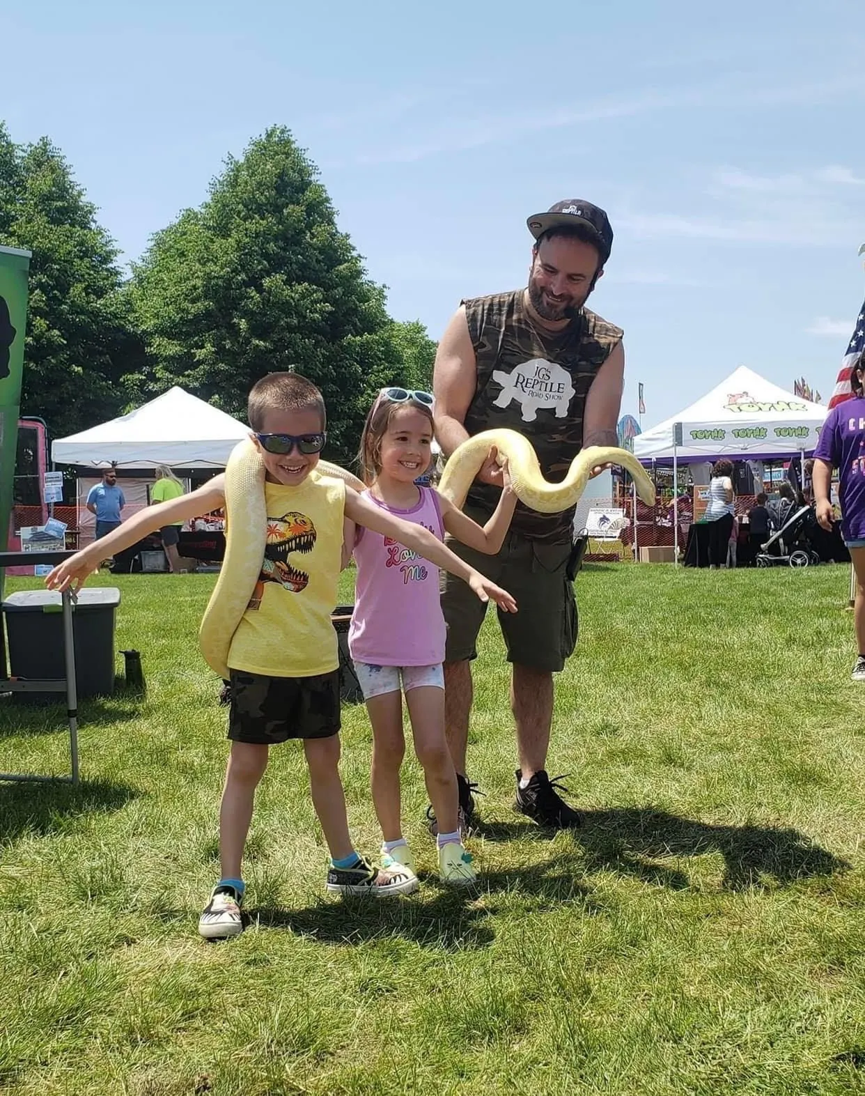 A child carefully holding a ball python at a birthday event