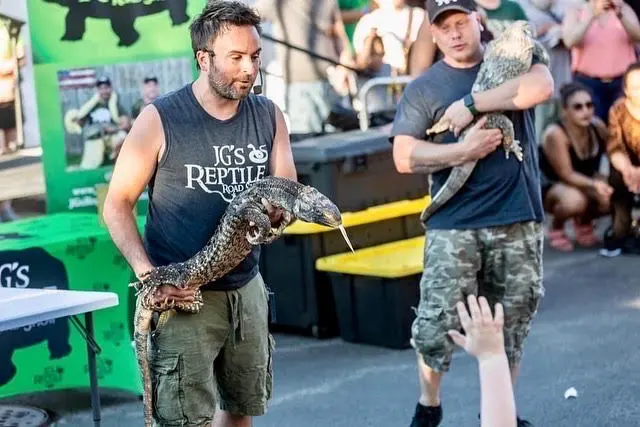 Jim walking through the crowd with a large python draped over his shoulders