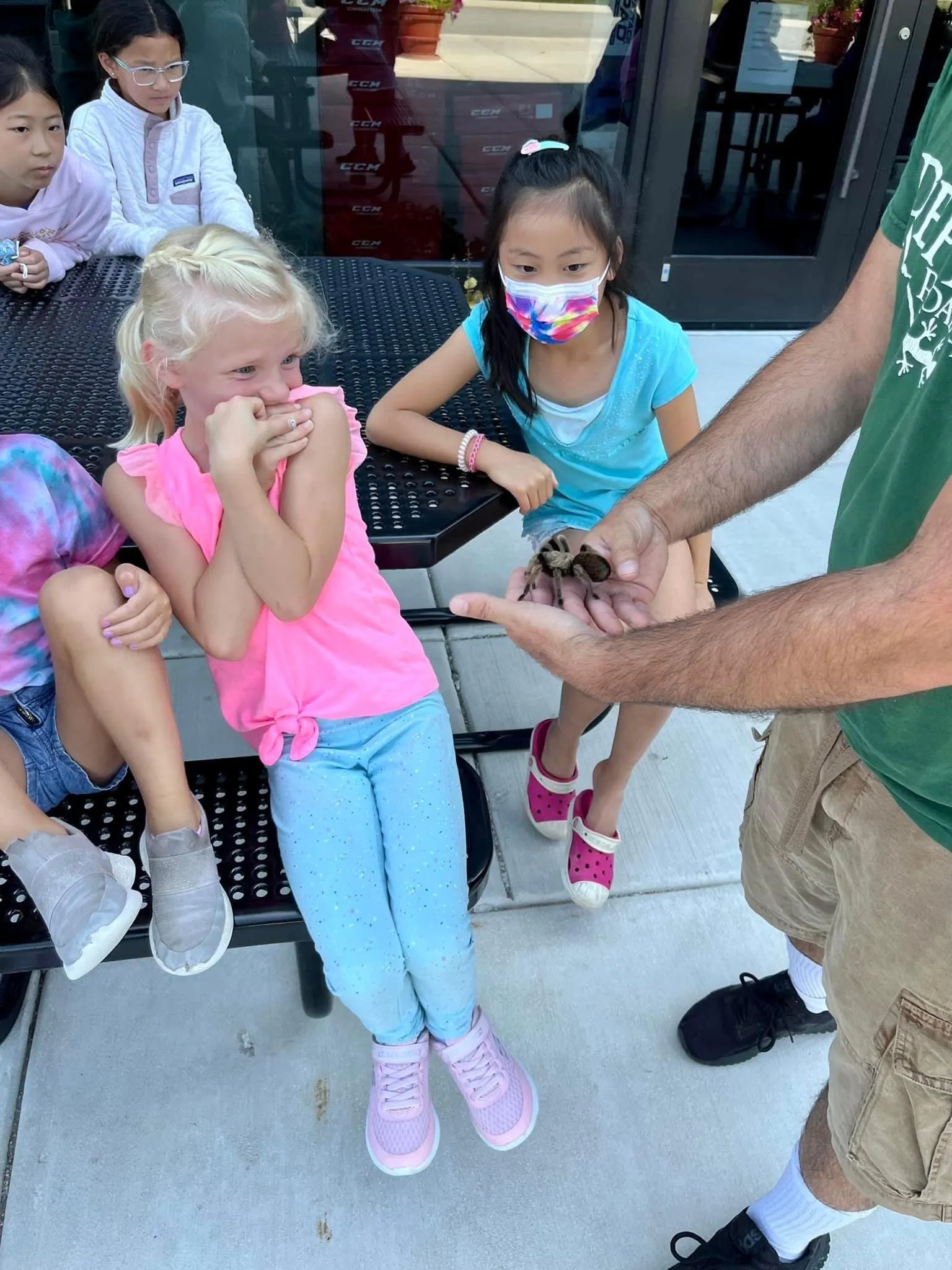 A happy group of birthday party guests surrounding the reptile display